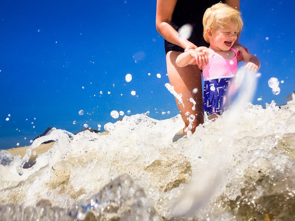 Kid playing in the waves on wrightsville beach in north carolina