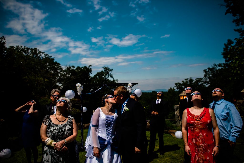 couple watching eclipse during their wedding
