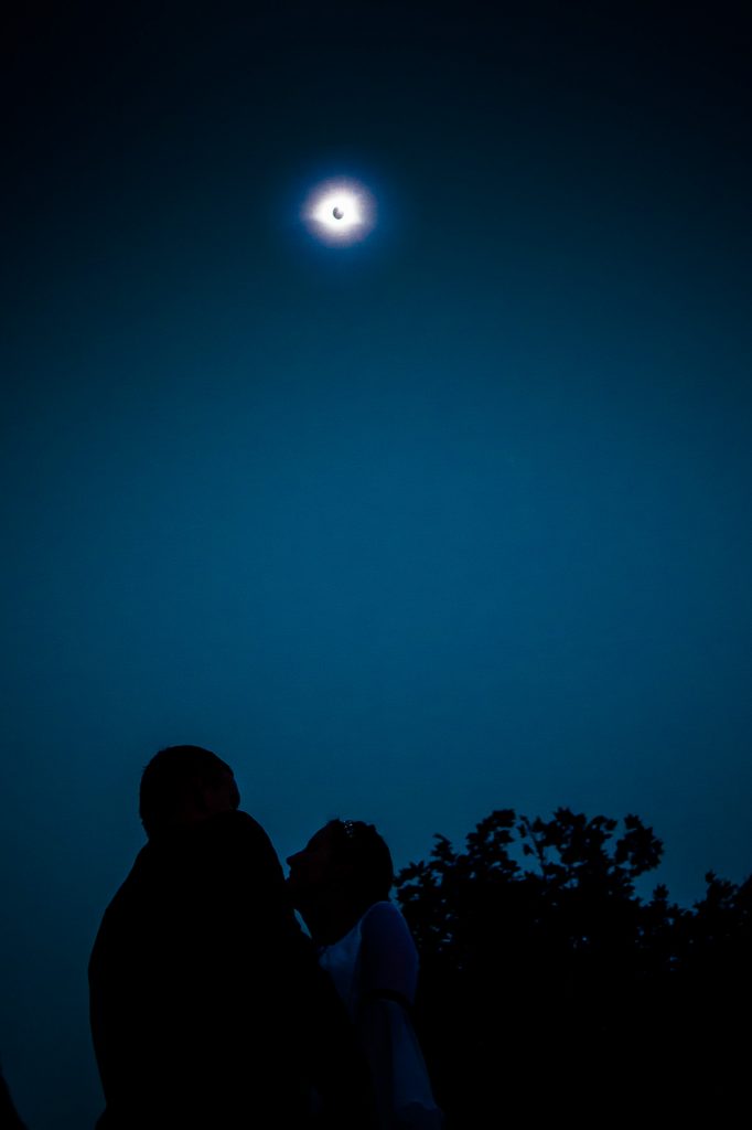 bride and groom watching totality eclipse wedding photo