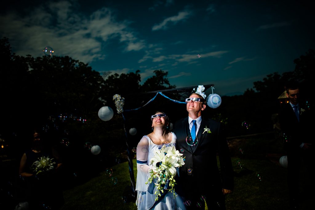 wedding couple watching eclipse glasses
