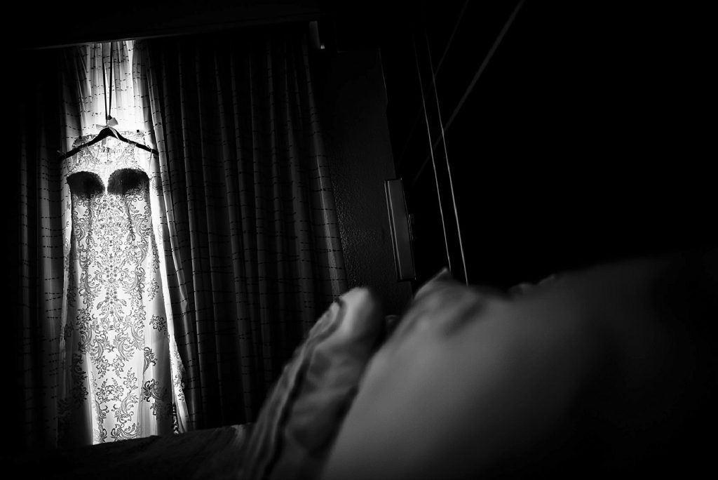 black white wedding dress hanging by window