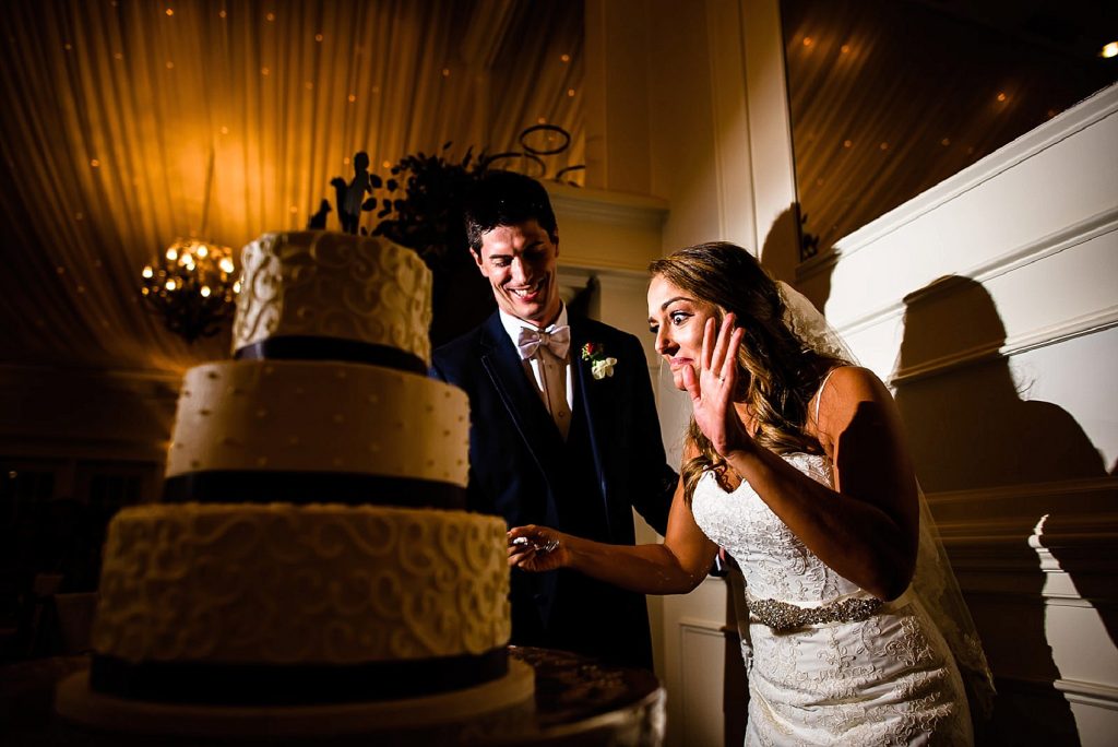 fun bride cutting her cake