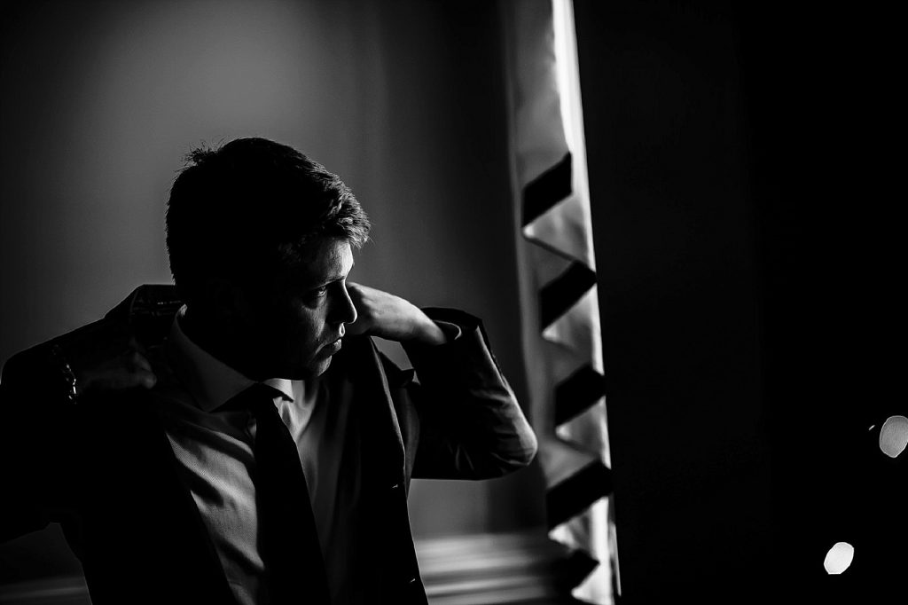 groom fixing tux before wedding