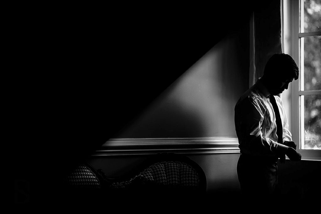 groom putting on cuff links