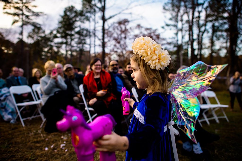 flower girl with bubbles coming down aisle