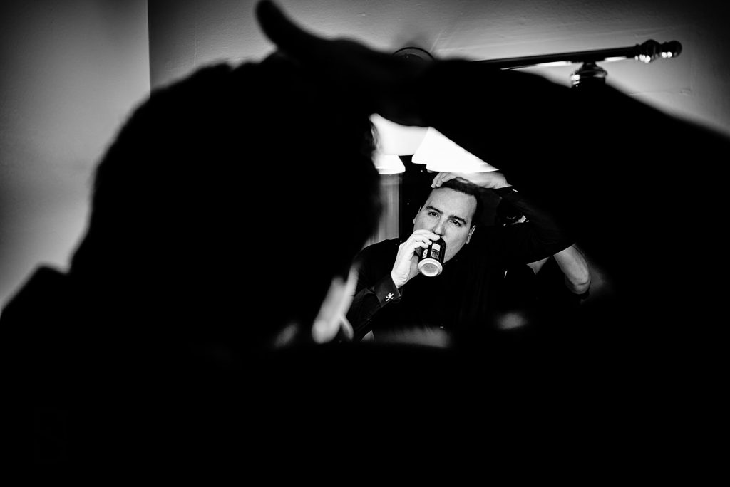 groom drinking beer while doing his hair